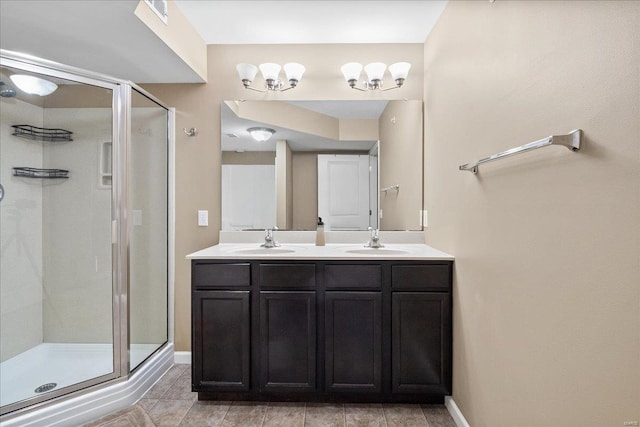 bathroom featuring a sink, baseboards, a stall shower, and double vanity