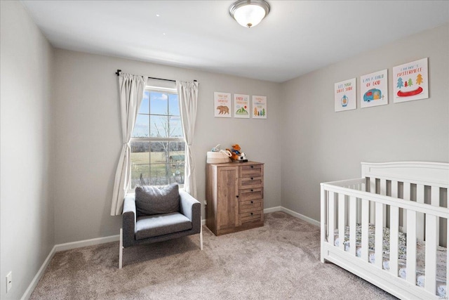 carpeted bedroom featuring a crib and baseboards