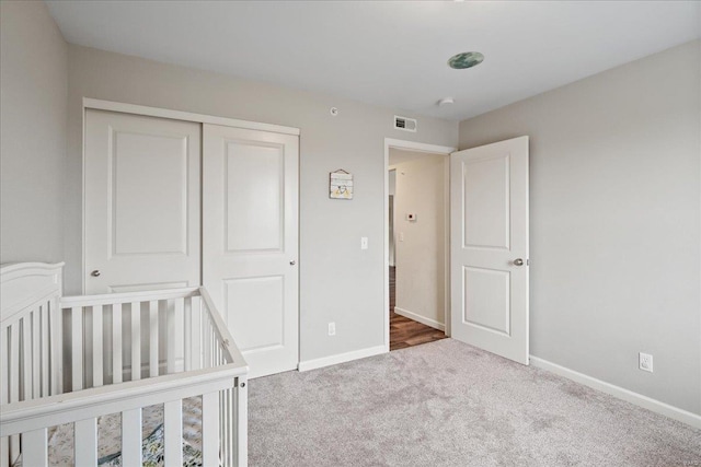 unfurnished bedroom with a closet, baseboards, and carpet floors