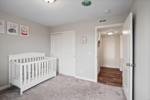 carpeted bedroom with a closet, baseboards, and visible vents