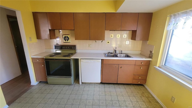 kitchen featuring range with electric cooktop, light countertops, a sink, and dishwasher