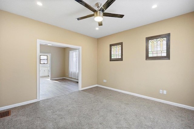 carpeted empty room featuring recessed lighting, visible vents, ceiling fan, and baseboards