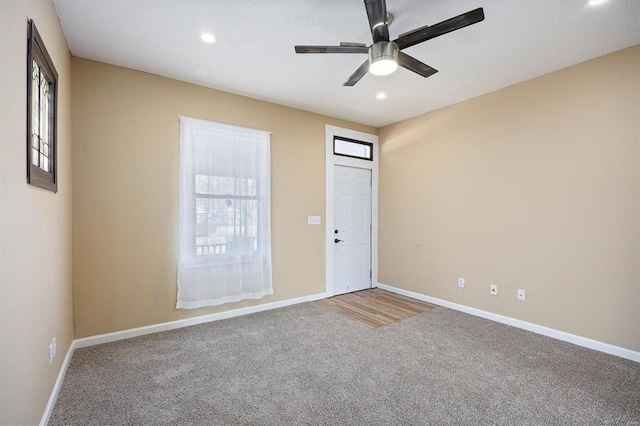 carpeted empty room featuring baseboards and a wealth of natural light