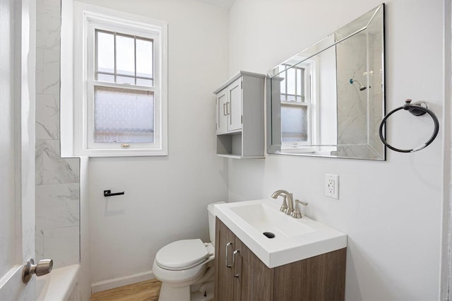 bathroom featuring baseboards, vanity, toilet, and wood finished floors