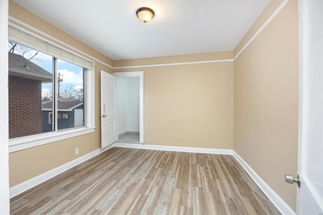 empty room with baseboards and wood finished floors