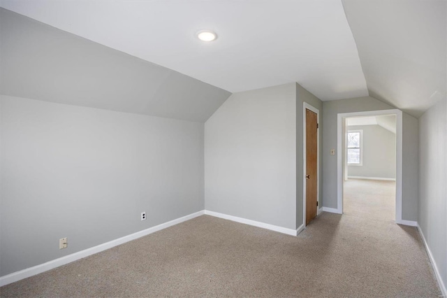 additional living space featuring lofted ceiling, carpet, and baseboards