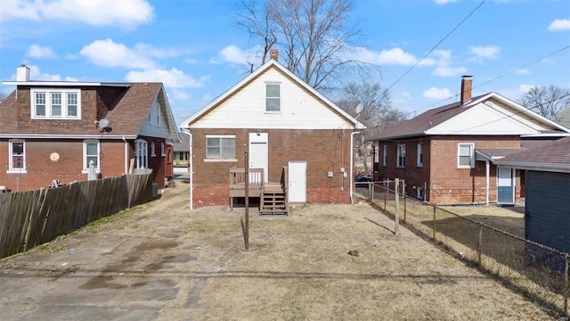 back of house with brick siding and a fenced backyard