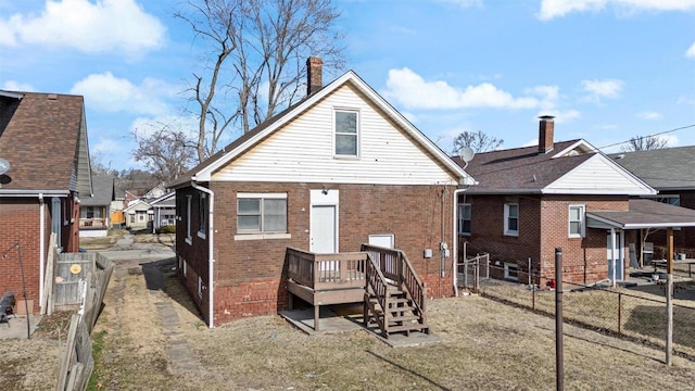 back of house featuring brick siding, a fenced backyard, and a wooden deck