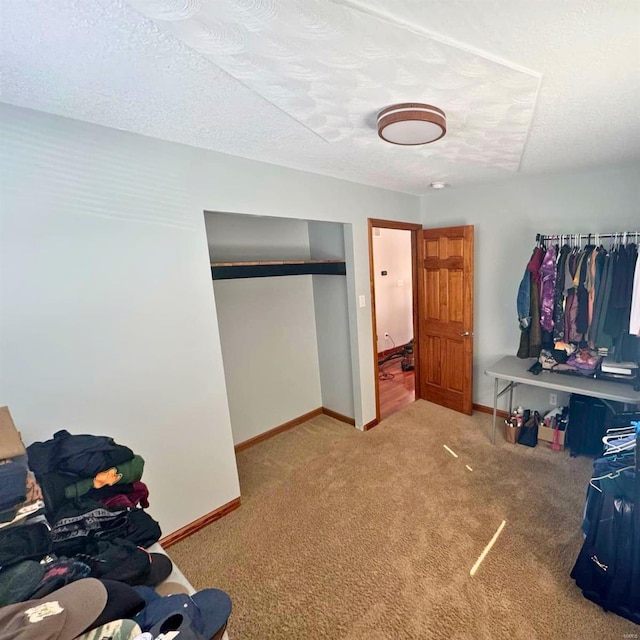 carpeted bedroom featuring a textured ceiling and baseboards