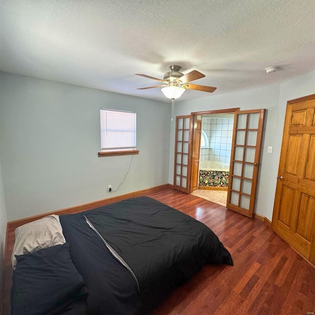 bedroom featuring ceiling fan, a textured ceiling, baseboards, and wood finished floors