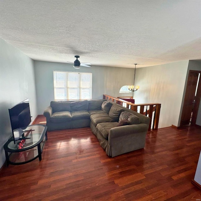 living area with a textured ceiling, dark wood finished floors, and a notable chandelier