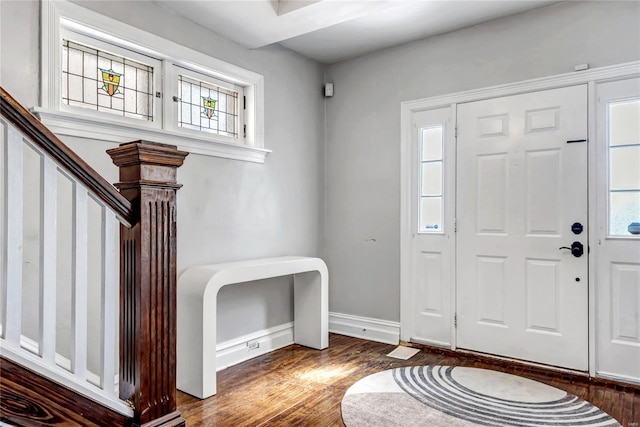 entryway featuring stairs, dark wood-type flooring, and baseboards