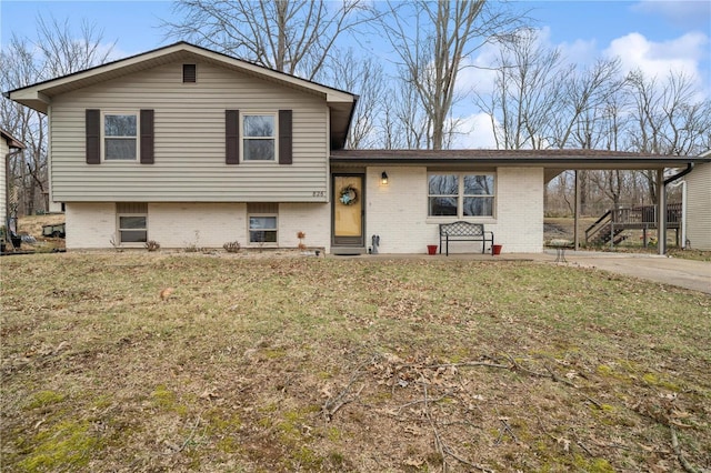 split level home featuring driveway, a front lawn, an attached carport, and brick siding