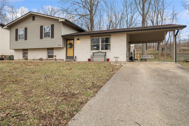 split level home featuring entry steps, an attached carport, brick siding, driveway, and a front yard