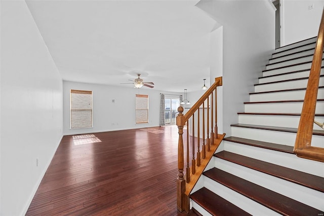 stairway featuring a ceiling fan, baseboards, and wood finished floors