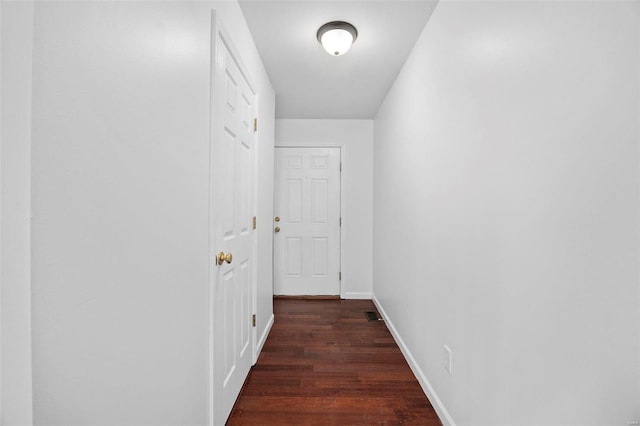 hall featuring baseboards and wood finished floors