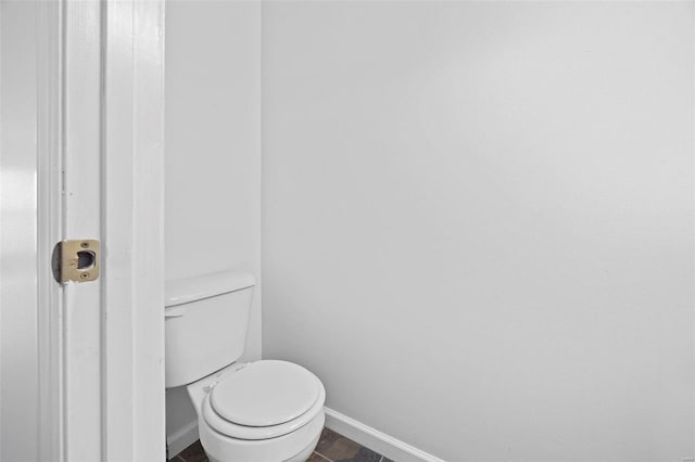 bathroom with toilet and baseboards