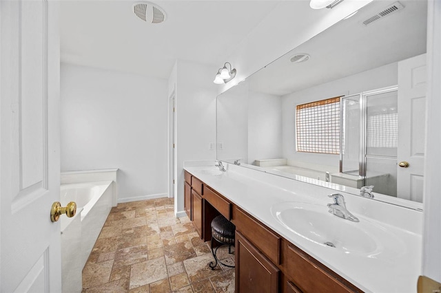 bathroom featuring visible vents, double vanity, a sink, and stone tile flooring