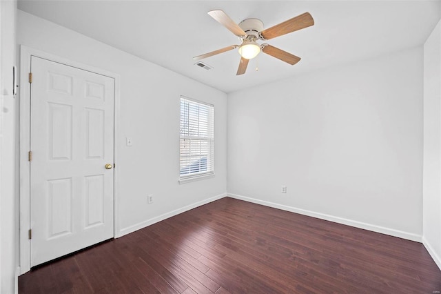 empty room with baseboards, visible vents, ceiling fan, and wood finished floors