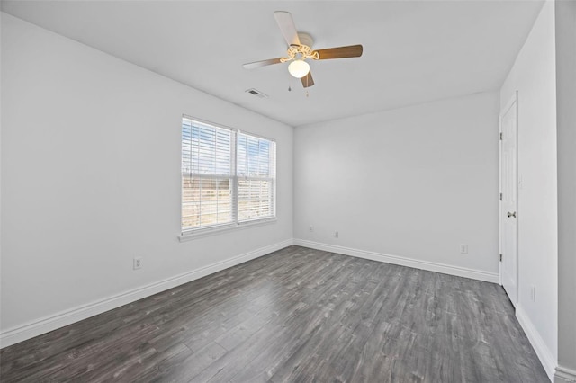 spare room featuring visible vents, dark wood finished floors, baseboards, and ceiling fan