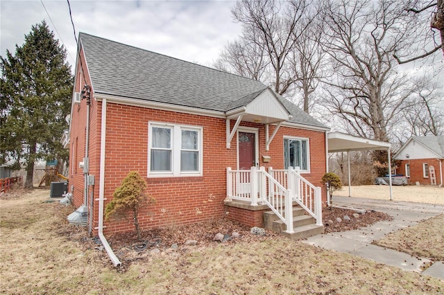 bungalow-style home with a carport, concrete driveway, brick siding, and roof with shingles