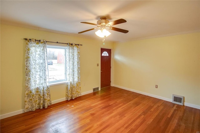 spare room featuring visible vents, baseboards, and wood finished floors