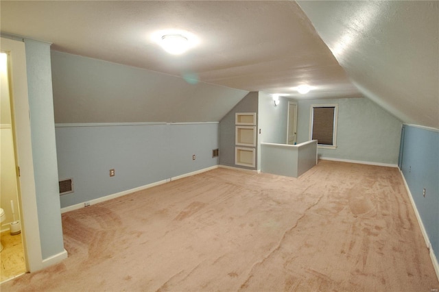 bonus room with baseboards, visible vents, vaulted ceiling, and carpet flooring