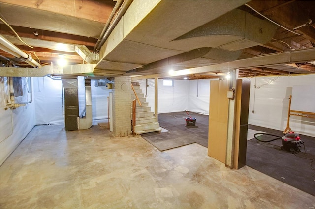 unfinished basement with stairway and heating unit