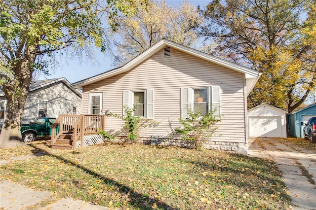 bungalow featuring a garage, an outbuilding, driveway, and a front yard