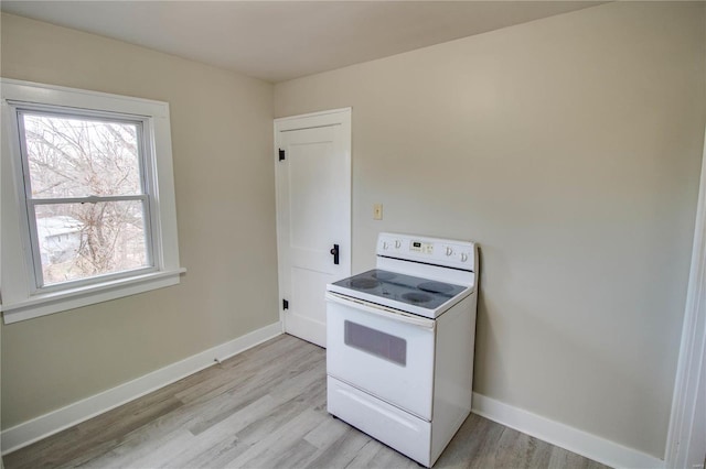 kitchen featuring light wood-style floors, electric range, and baseboards