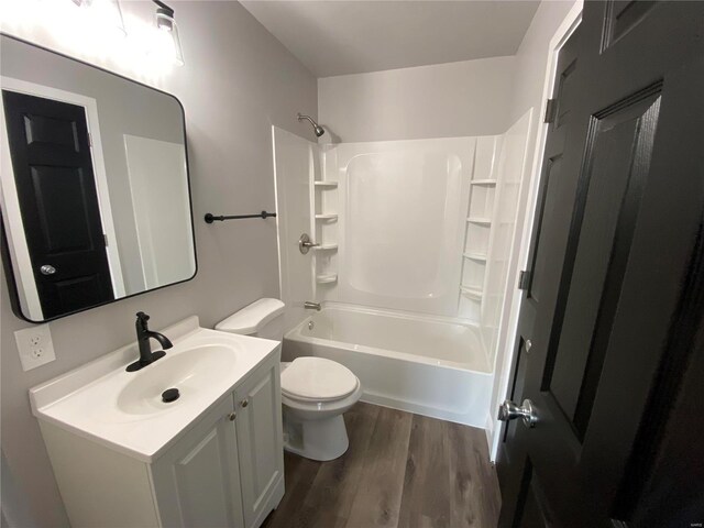 bathroom featuring vanity, shower / bathing tub combination, wood finished floors, and toilet