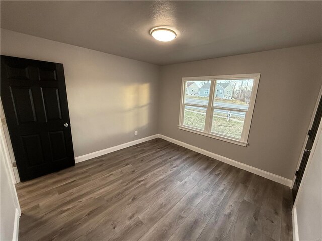 unfurnished bedroom with dark wood finished floors and baseboards