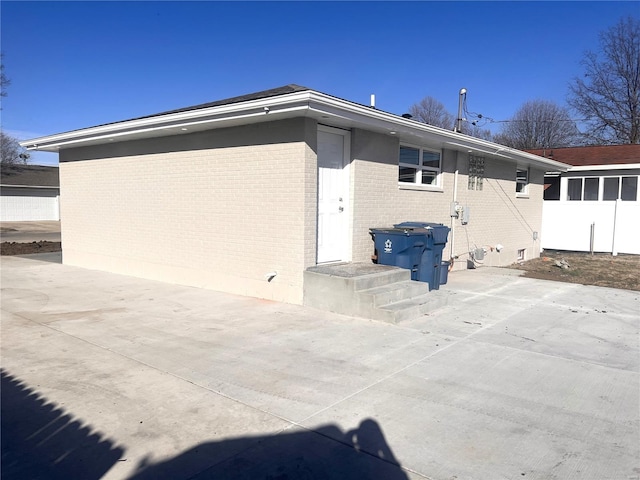 back of house with brick siding and a patio