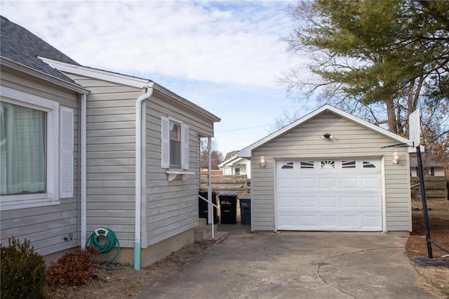 view of side of home featuring a garage, an outdoor structure, and driveway