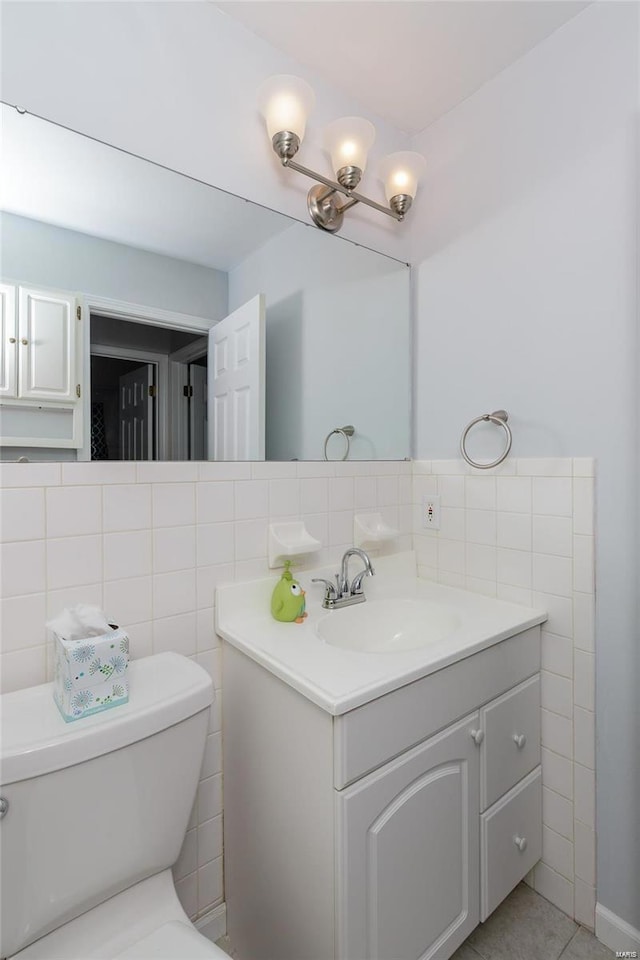 bathroom featuring vanity, toilet, and tile walls