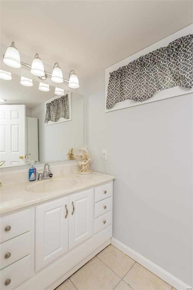 bathroom with baseboards, vanity, and tile patterned floors