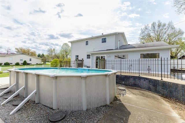 rear view of property featuring a fenced in pool and fence