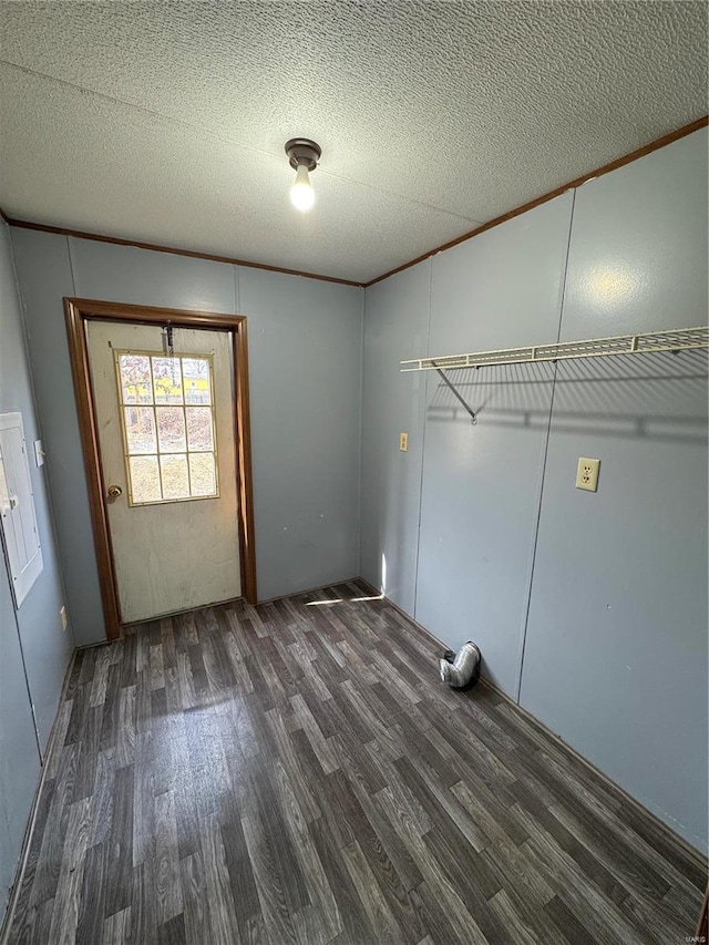 washroom featuring a textured ceiling, ornamental molding, and dark wood-style flooring