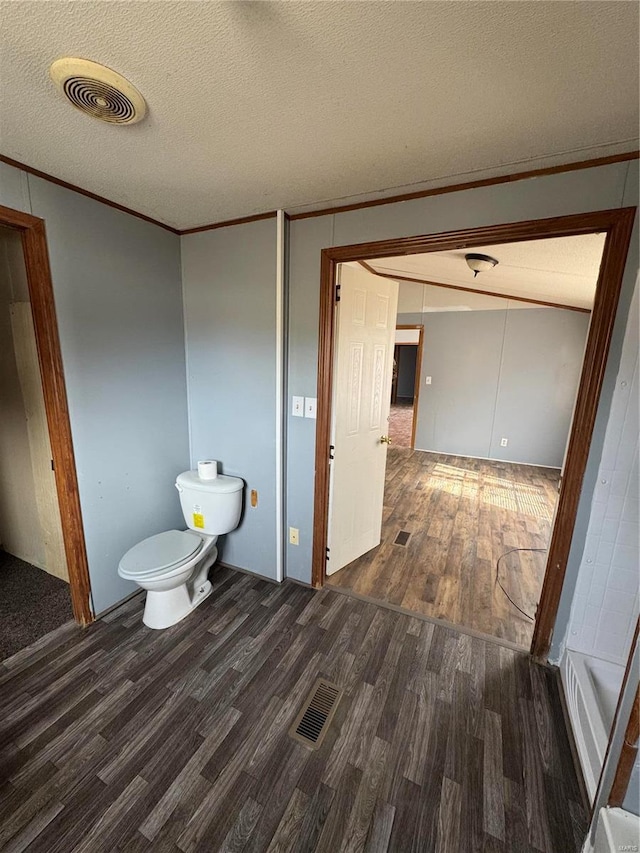 bathroom with visible vents, crown molding, a textured ceiling, and wood finished floors