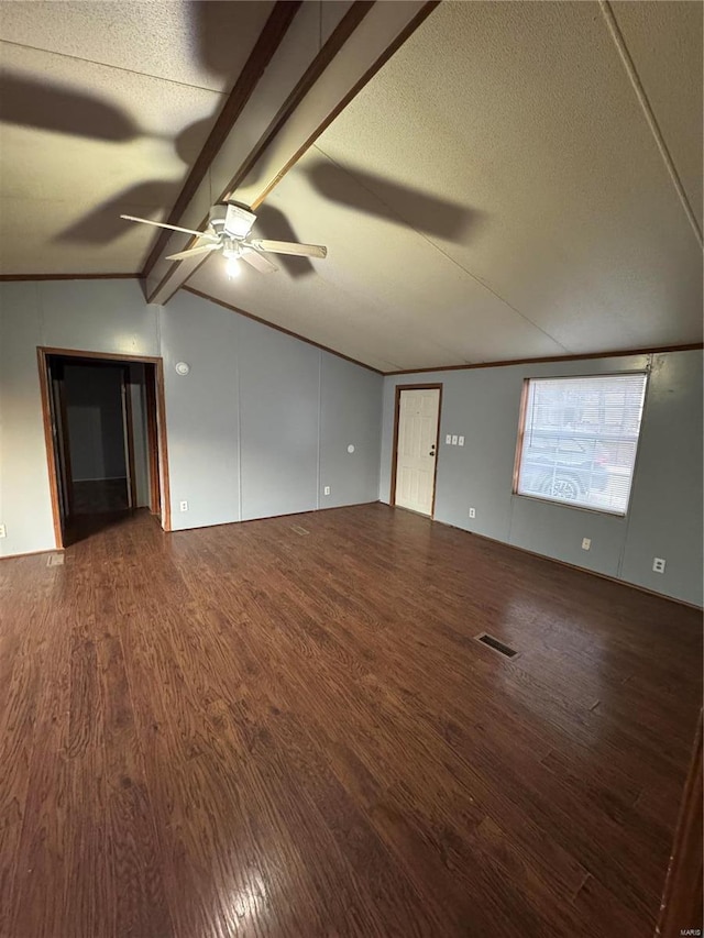 empty room with dark wood-style flooring, visible vents, lofted ceiling with beams, and a textured ceiling