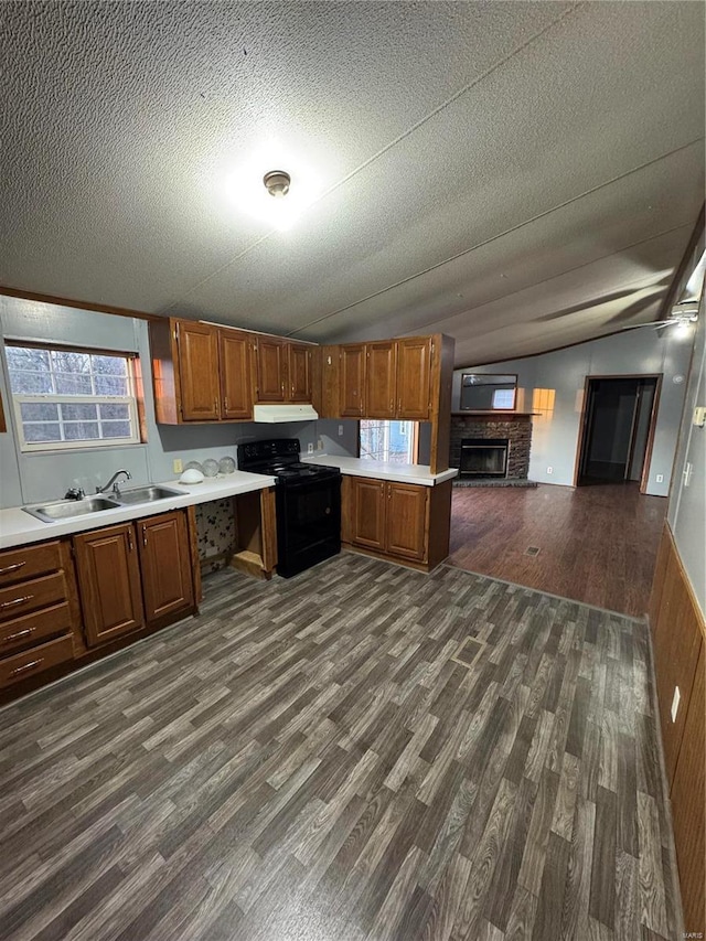 kitchen with light countertops, black electric range oven, open floor plan, vaulted ceiling, and under cabinet range hood