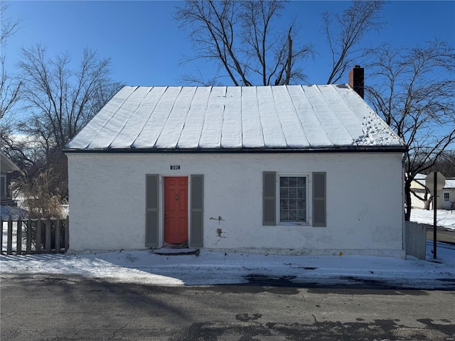 view of front of property featuring a chimney and fence