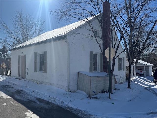 snow covered property featuring metal roof