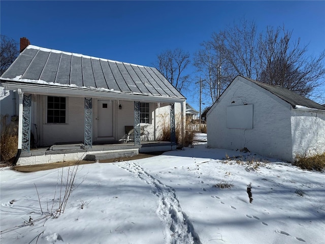 view of front of home with a standing seam roof, metal roof, and covered porch