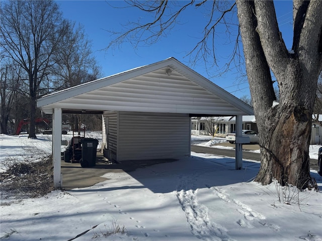 view of snowy exterior featuring a detached carport and faux log siding