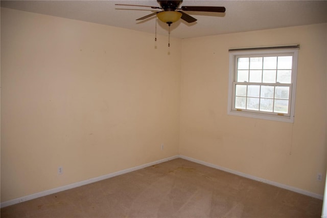 empty room featuring light carpet, a ceiling fan, and baseboards