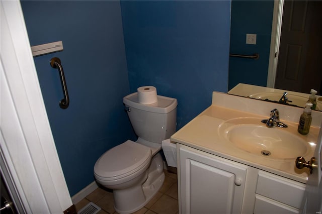 bathroom with visible vents, toilet, vanity, baseboards, and tile patterned floors