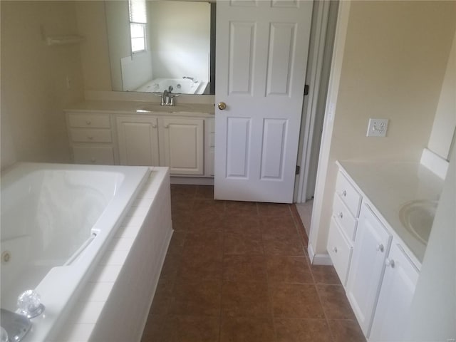 bathroom featuring tile patterned flooring, vanity, and a tub with jets