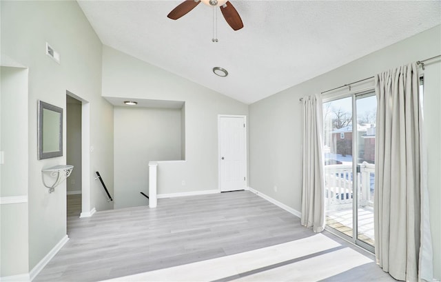 spare room featuring baseboards, visible vents, vaulted ceiling, and light wood finished floors