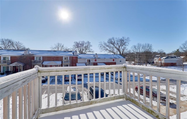 snow covered back of property with a residential view